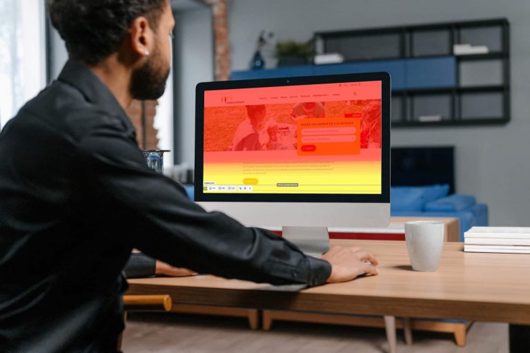 Man die op zijn laptopscherm naar een heatmap kijkt in de kleuren rood en geel. Hoe warmer de kleur, hoe meer mensen dat deel van de pagina zien. Met heatmaps op je website analyseer je of bezoekers daadwerkelijk klikken waar ze ‘moeten’ klikken en je boodschap meekrijgen. Een essentiële tool voor organisaties die op basis van gebruikersdata hun website willen verbeteren.